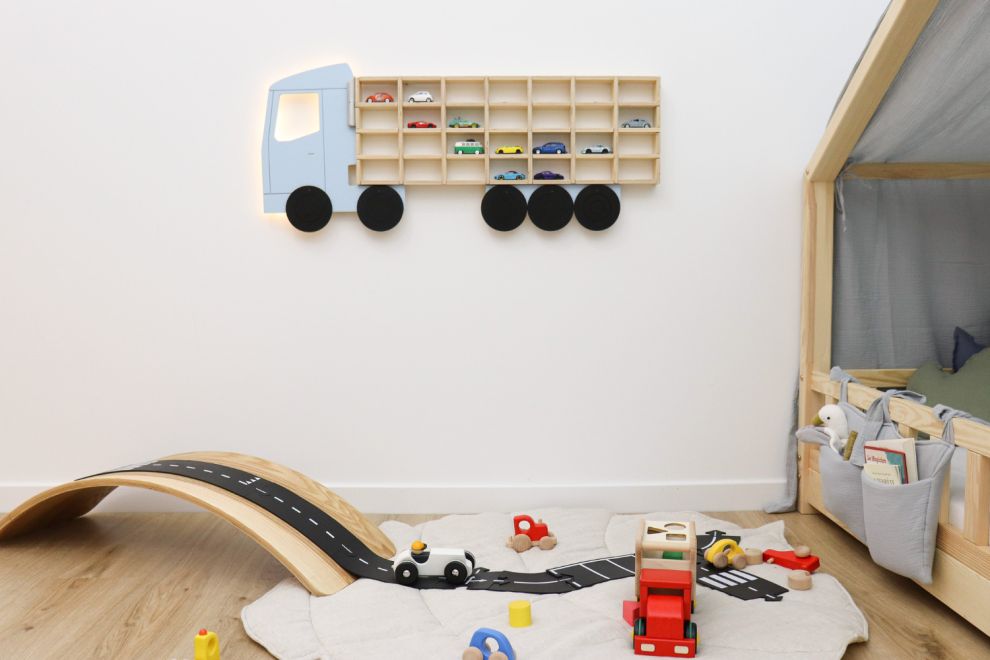 Collection colorée de voitures jouets en bois sur une étagère